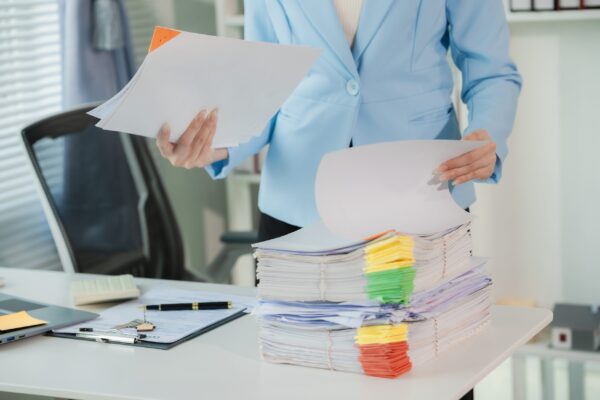 Close-up,Of,Businesswoman,Holding,A,Pile,Of,Documents,At,Her
